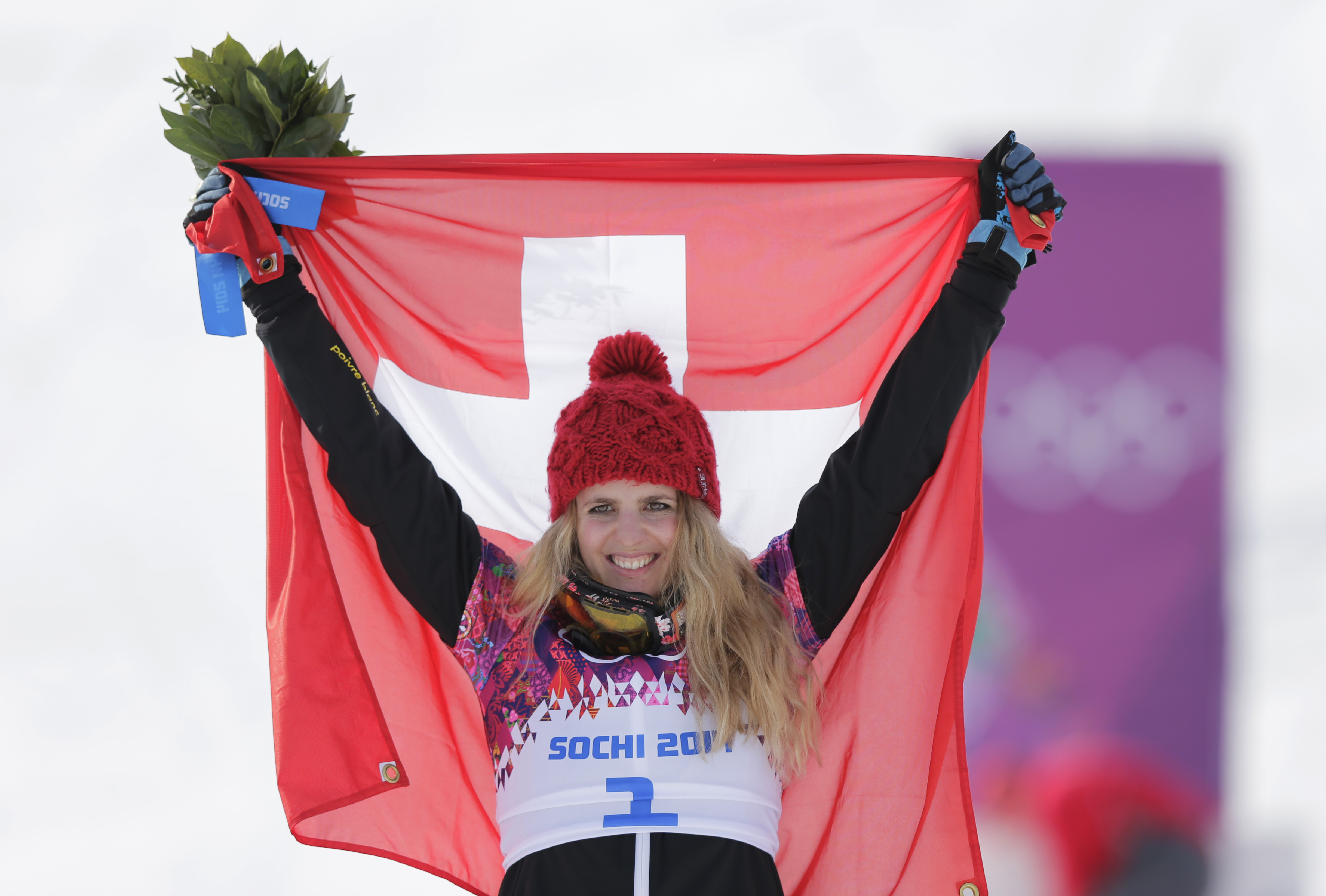 Women's snowboard parallel giant slalom gold medalist Switzerland's Patrizia Kummer celebrates with the national flag at the Rosa Khutor Extreme Park, at the 2014 Winter Olympics, Wednesday, Feb. 19, 2014, in Krasnaya Polyana, Russia. (AP Photo/Andy Wong)
