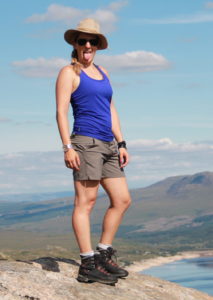 Patrizia Kummer steht zu Oberst auf einem Högel in Schottland und geniesst die Aussicht auf die Umliegende Bergwelt.